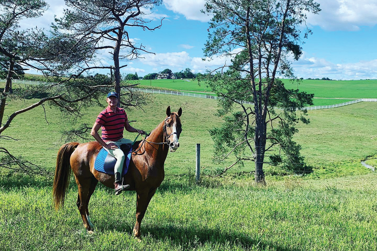 Kressley riding a chestnut horse in a field