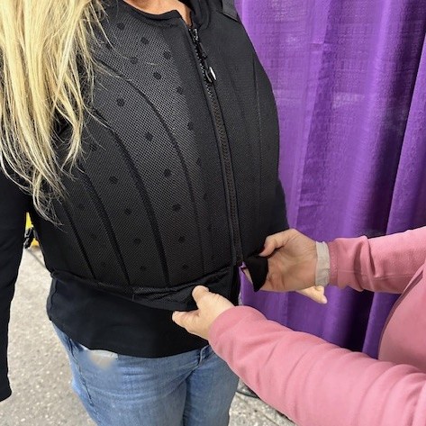 Chick ensures the safety vest falls about an inch past the lowest rib, measuring on either side of the belly button.