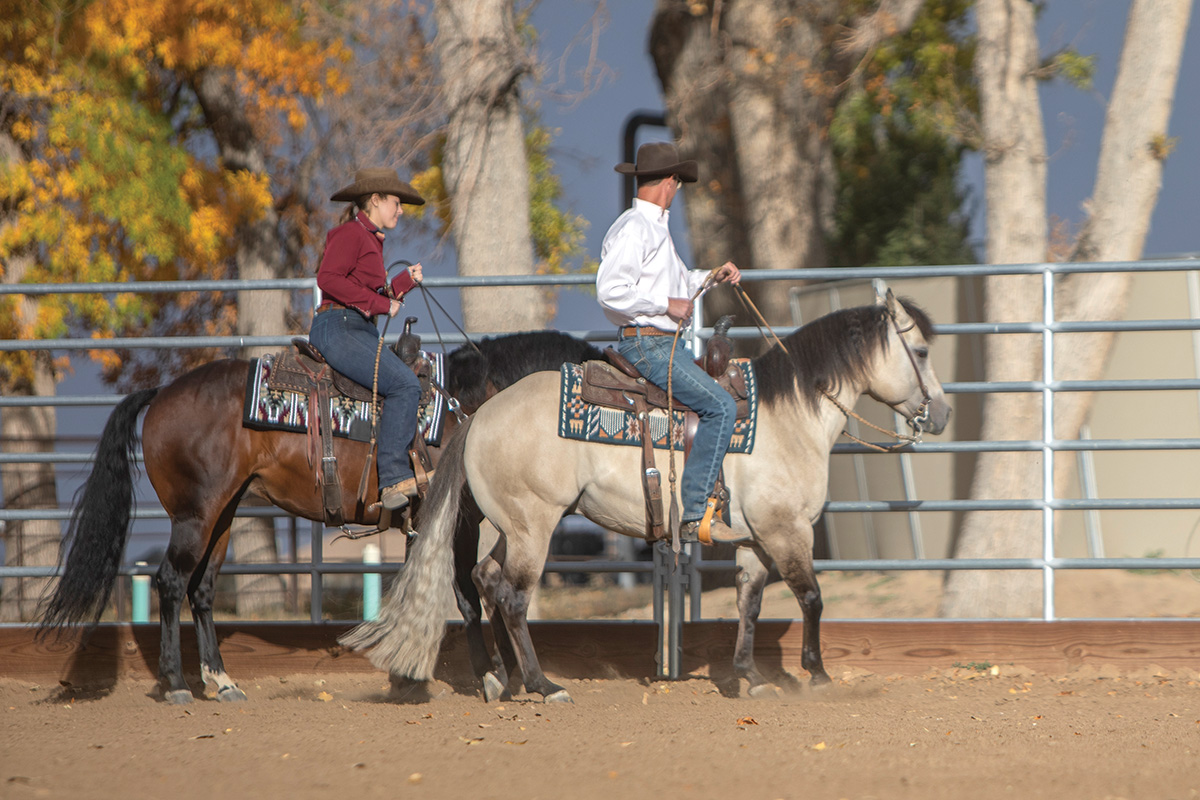 A rider bringing his horse even with another horse and rider