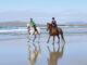 Horseback riding on a beach in Ireland on holiday.