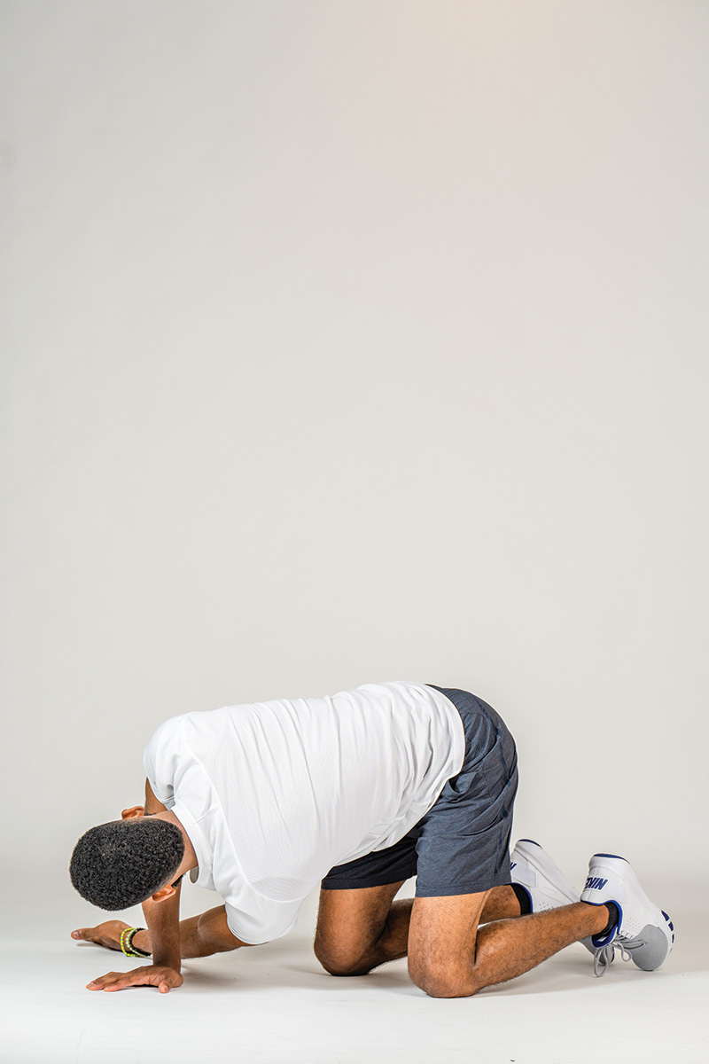 The author demonstrates the threading the needle exercise, which helps prevent rider back pain.