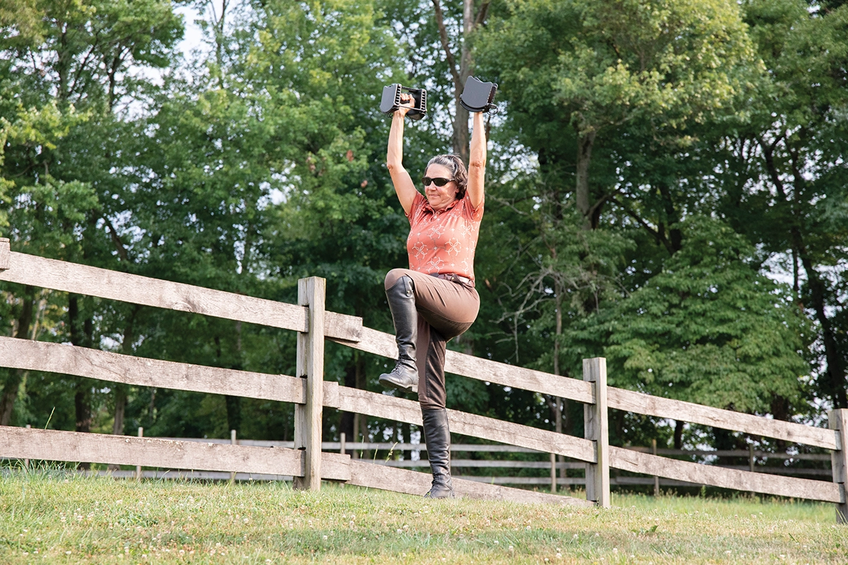 A woman performs a marching press.