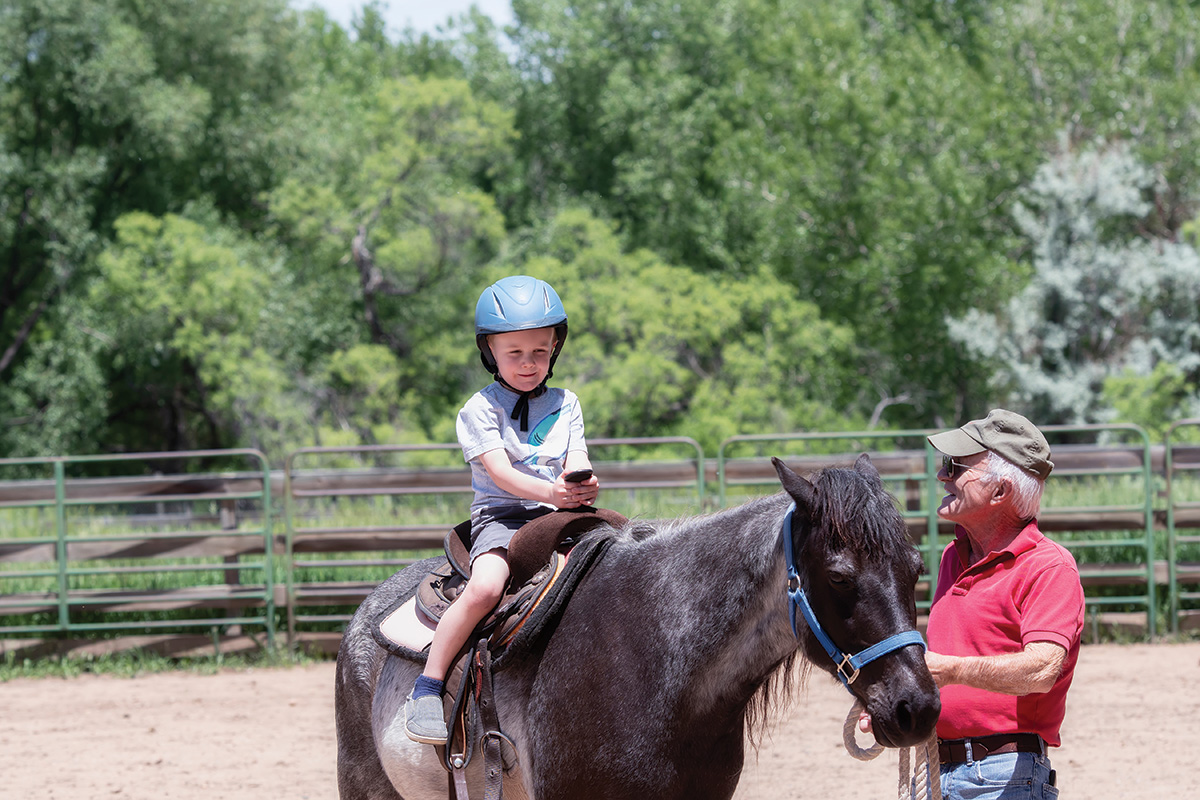A young girl taking a riding lesson.