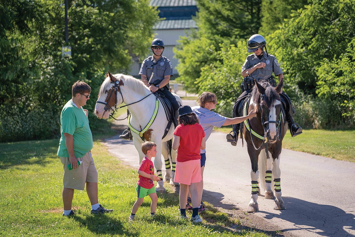 Kentucky Horse Park mounted police pause to chat with a family visiting the park.
