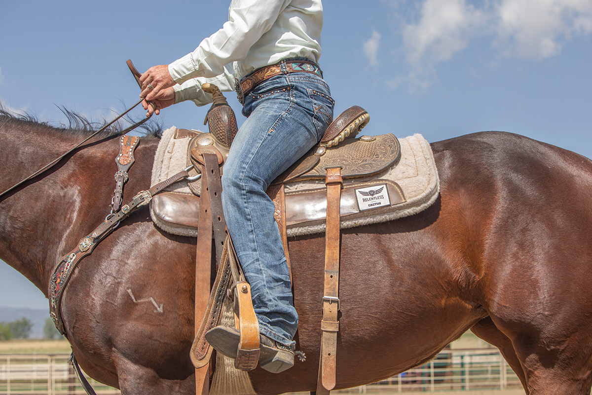A barrel racing rider demonstrating the riding position to push a horse forward