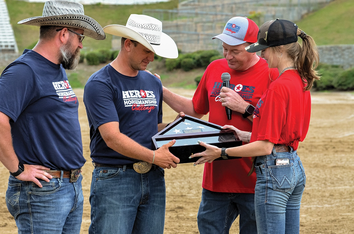 2024 competitor Joe Conwell presents Heroes Horsemanship Challenge event coordinator Jake Hartman with a flag flown while he was serving in Kuwait. 