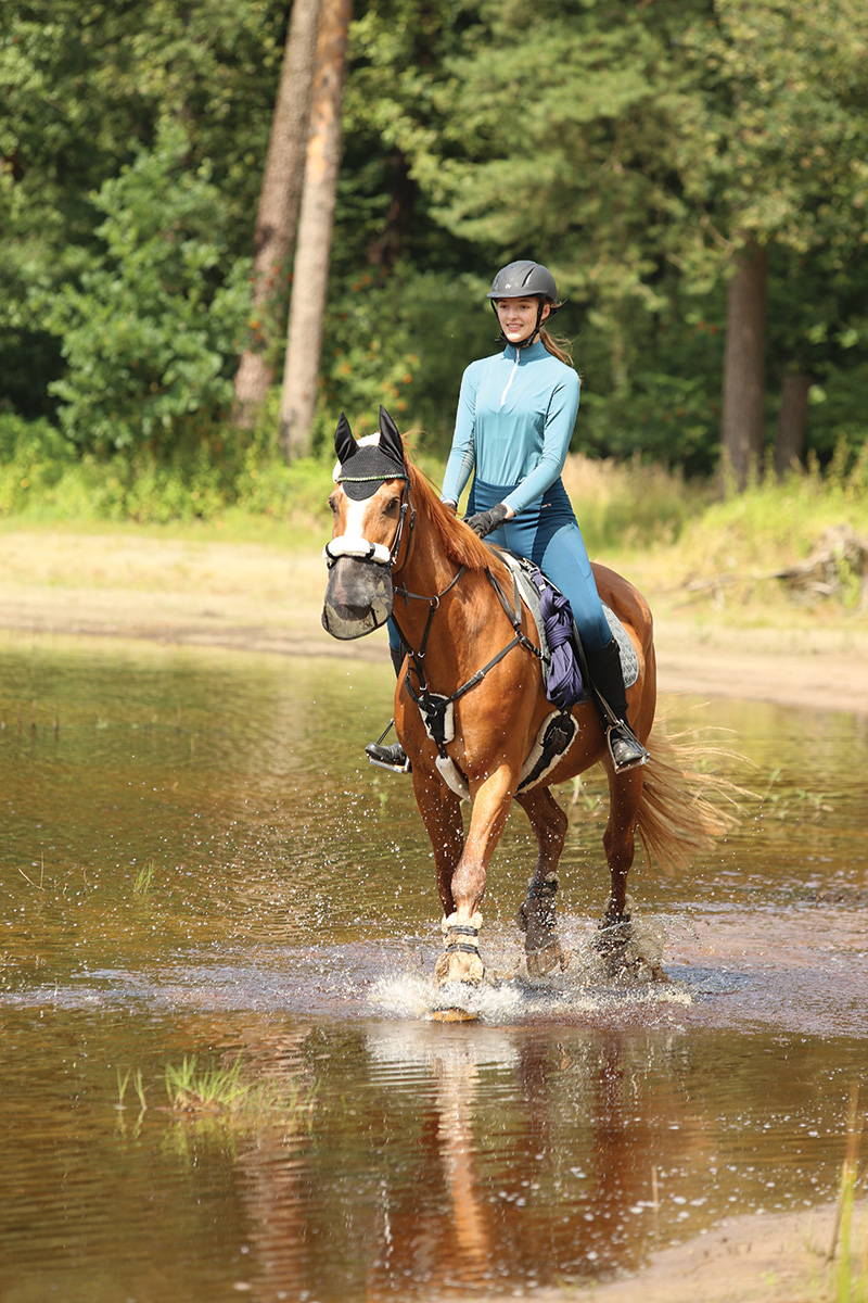 Emily riding her cousin’s horse through the water in the German countryside.