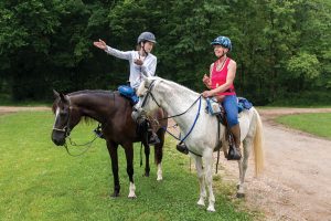 Horse riders getting compass reading.