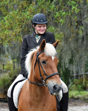 Young girl riding horse.