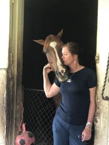 Sue Lyman at barn with horse. 