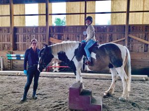 Horse and rider in arena with trainer.