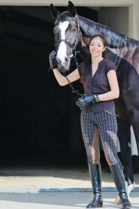 Woman standing next to horse.